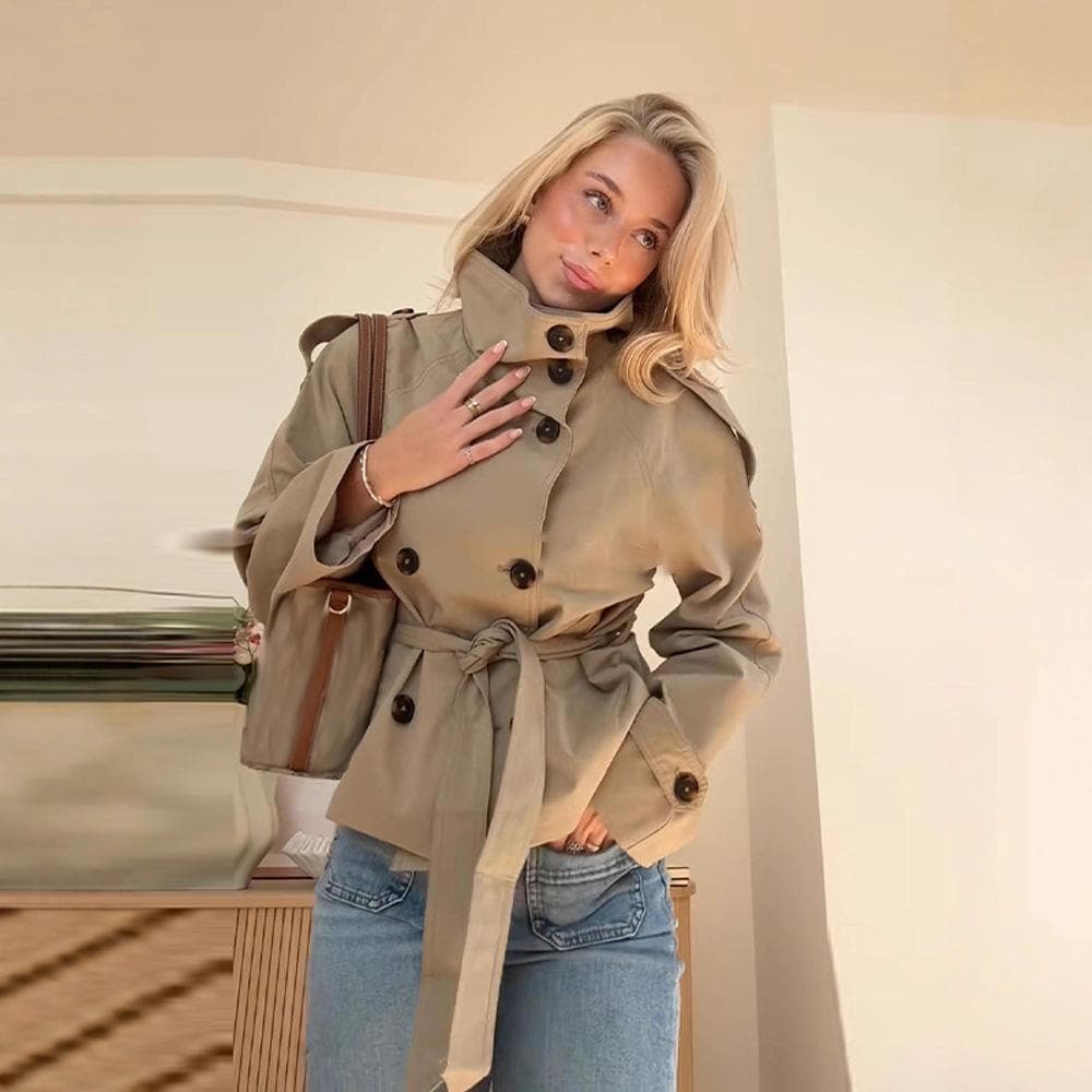 Kort dame-trenchcoat med høy krage, blå denimjeans og brun crossbody-veske, avslappet chic antrekk cm khaki